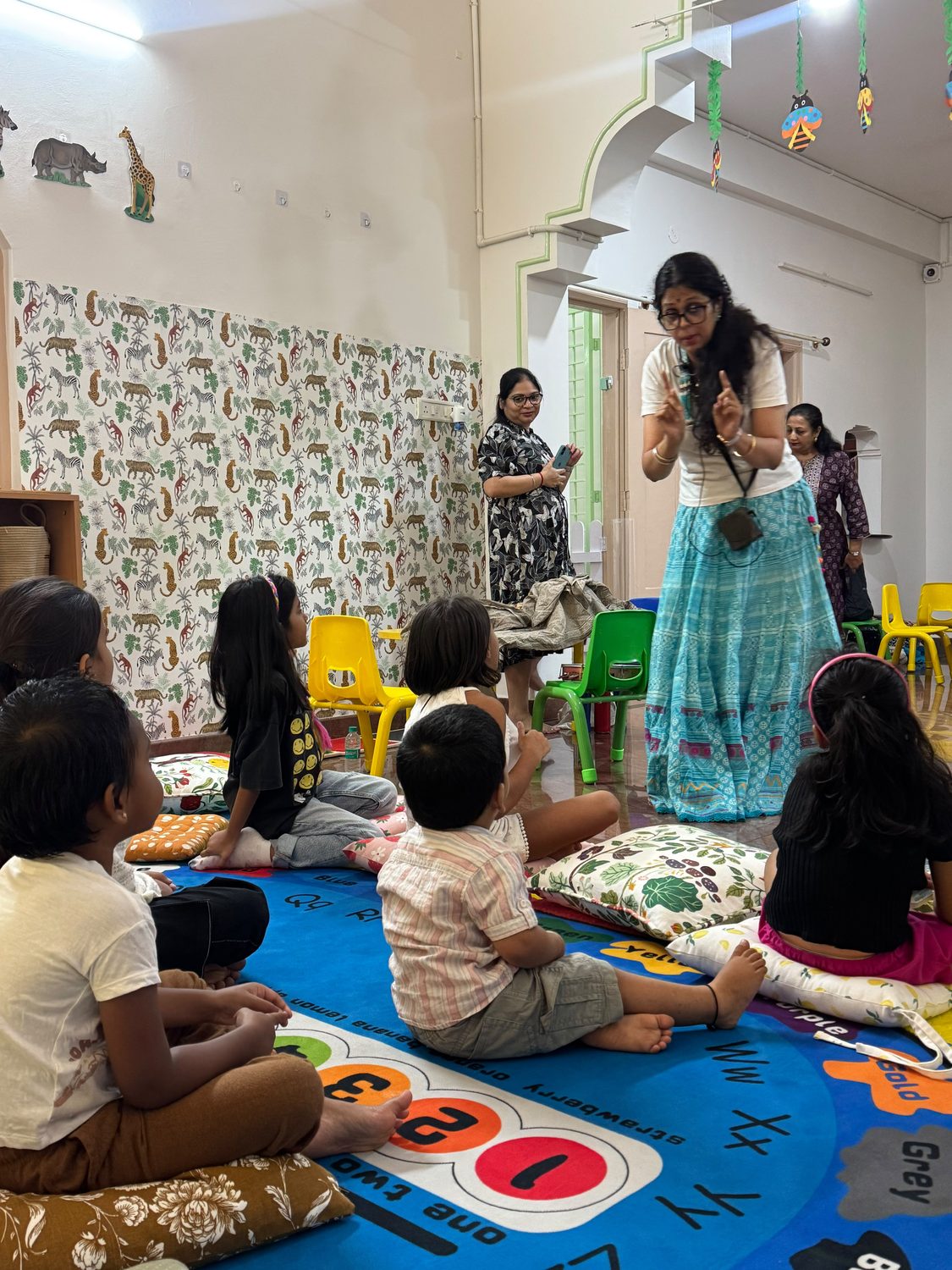 Children and an educator sharing a classroom circle-time activity at Tender Moments Hebbal