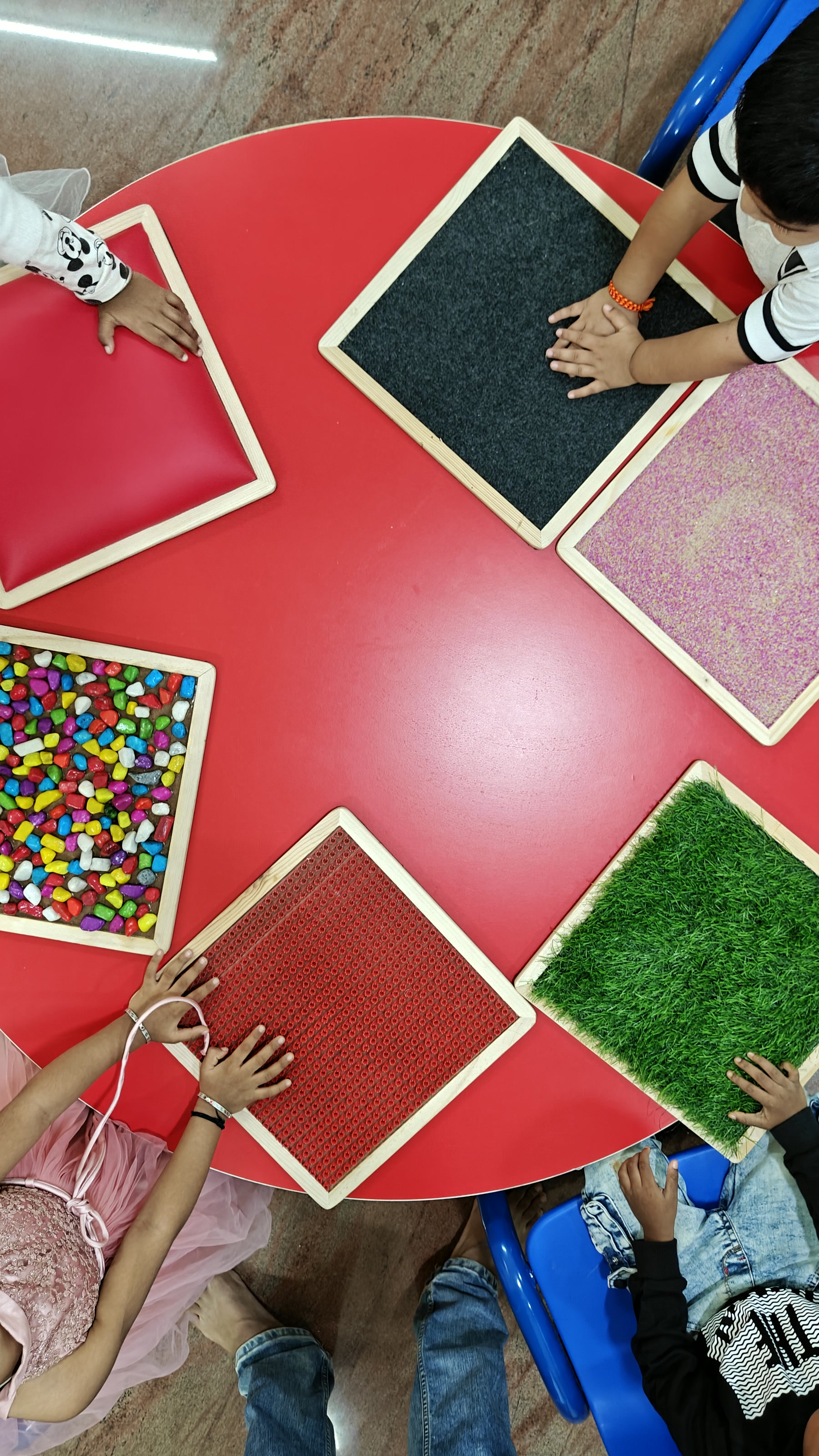 Textured geometric materials arranged on a red table