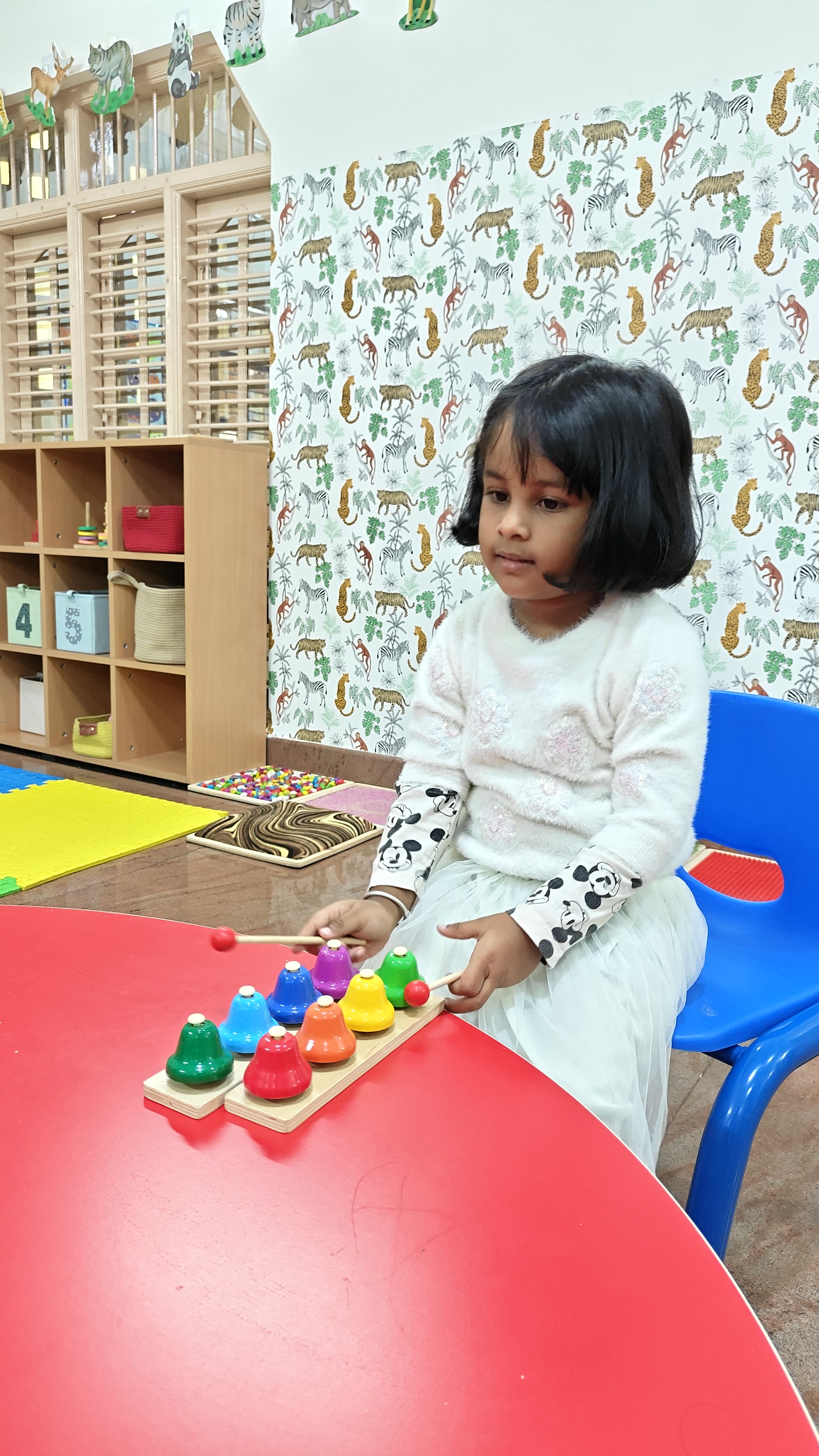 Child arranging colourful materials into a pattern